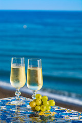 Romantic event, bottle with cold sparkling wine, cava or champagne served with two glasses on table...