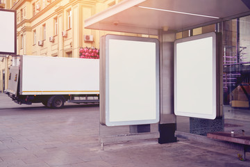 Empty billboards, advertising placeholder on a public bus stop, truck behind near house, mockup of a blank white poster.