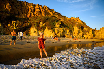 People enjoying the sun, the warm wind and the perfect sunset at the popular El Matador Beach in Malibu, California West Coast, USA
