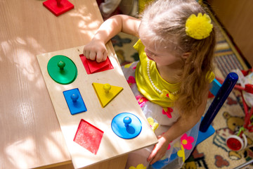 Girl with down syndrom developing motor skills in rehab center for special children
