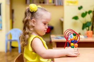 Girl with down syndrom developing motor skills in rehab center for special children
