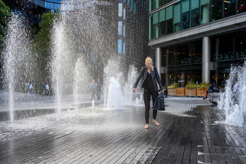People in London, walking through between the water jets and fountains