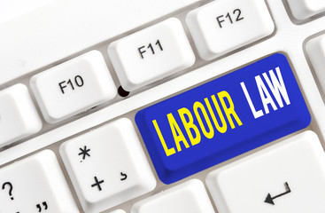 Text sign showing Labour Law. Business photo showcasing Rules implemented by the state between employers and employee White pc keyboard with empty note paper above white background key copy space