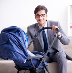 Businessman looking after newborn baby at home and teleworking