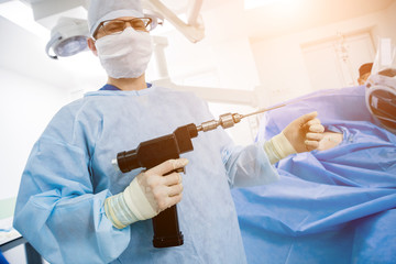 Arthroscope surgery. Orthopedic surgeons in teamwork in the operating room with modern arthroscopic tools.