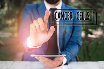 Handwriting text writing Cancer Cells. Conceptual photo forming solid tumors or flooding the blood with abnormal cells Businessman with pointing finger in front of him