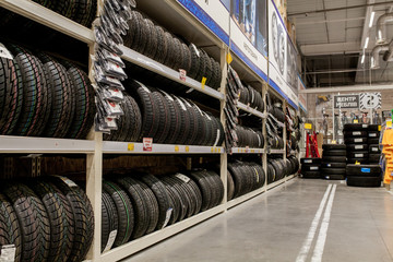Rack with variety of car tires in automobile store - obrazy, fototapety, plakaty