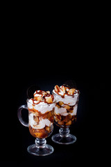 Sweet dessert in glass with biscuit and whipped cream on pink bsckground, selective focus and blank space
