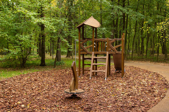 A modern playground made from natural materials that blend into the landscape design. Swing in the yard