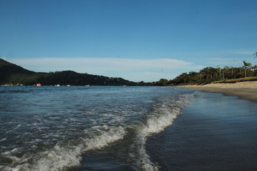 Praia do Cruzeiro in Ubatuba, São Paulo, on a sunny day with calm waters and a serene coastal view. Located in the city center, this tranquil beach is a popular spot for relaxation