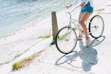 partial view of girl riding bike near river in summer