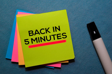 Back in 5 Minutes on sticky notes isolated on Office Desk