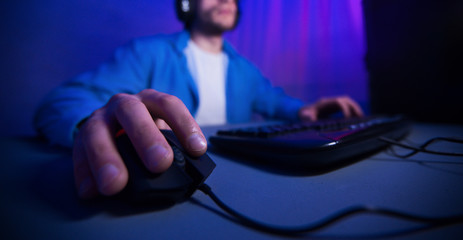 Male hand using computer mouse playing online games