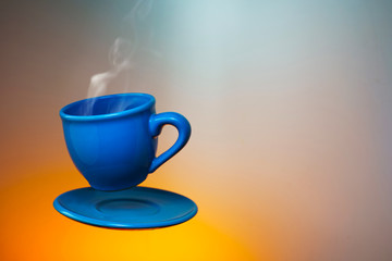 Floating blue cup of espresso. Mock up of soaring in the air cup of hot coffee