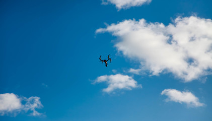 Naklejka na ściany i meble the quadcopter hovered above the clouds against the blue sky