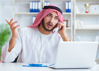Arab businessman working in the office doing paperwork with a pi