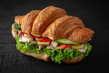 Dietary Croissant sandwich with boiled chicken, mushrooms, cheese, tomatoes, lettuce. Healthy, tasty, nourishing snack. Take away food