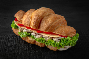 Dietary Croissant sandwich with boiled chicken, mushrooms, cheese, tomatoes, lettuce. Healthy, tasty, nourishing snack. Take away food