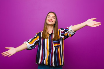 young pretty woman smiling cheerfully giving a warm, friendly, loving welcome hug, feeling happy...