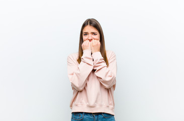 young pretty woman looking worried, anxious, stressed and afraid, biting fingernails and looking to...