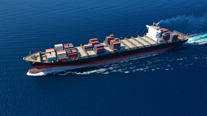 Aerial photo of large cargo container ship cruising the deep blue Mediterranean sea