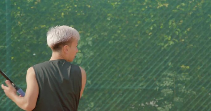 Close up of a tennis player volleying in slow motion.