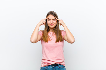 young pretty woman with a serious and concentrated look, brainstorming and thinking about a...