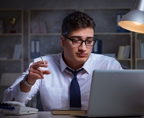 Businessman under stress smoking in office