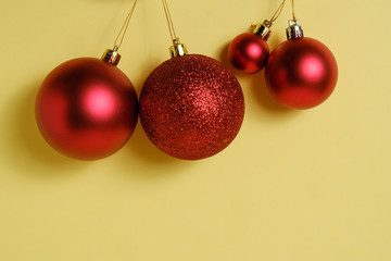 Red christmas balls on whatman yellow paper background.