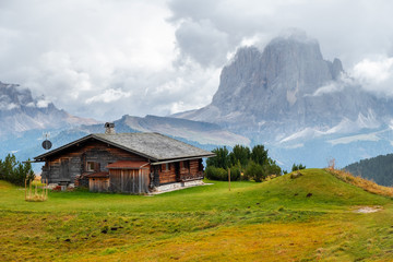 Obraz premium Mountain meadow and houses in Gardena valley and Seceda peak , background Alpe di Siusi or Seiser Alm in the with Province of Bolzano, South Tyrol in Dolomites