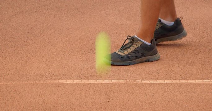 Close up of a tennis player clearing the baseline on a clay tennis court 