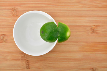 Limón partido sobre tazón y plato blanco