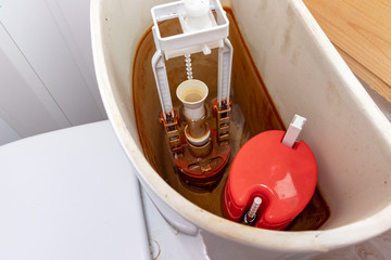 Dirty unhygienic rusty and calcified flush tank of toilet with limescale and rust stains and scum...