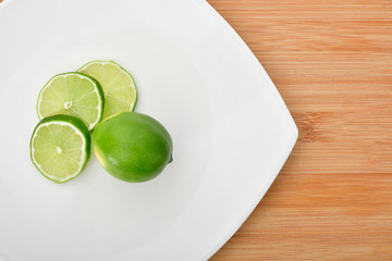 Limón en rodajas en tazón y plato blanco