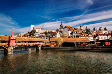 View to the old town buildings and wooden bridge over Reuss river in Lucerne, Switzerland