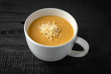 Cream soup made of pumpkin, spinach, broccoli and lentils with parmesan, pumpkin seeds and cream. Tasty, healthy nutritious lunch.