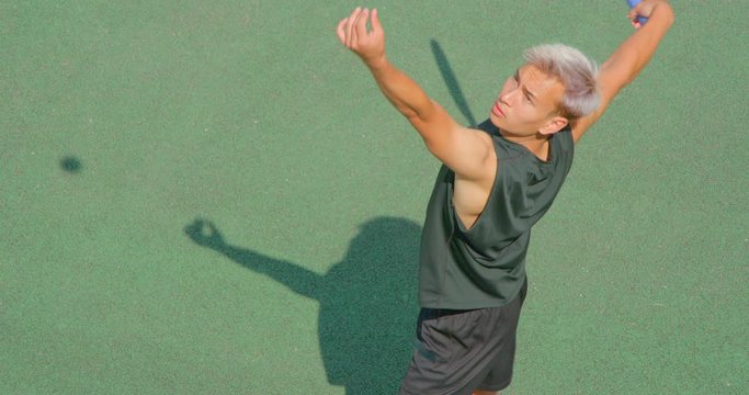 Close up of a mixed race tennis player serving in slow motion.