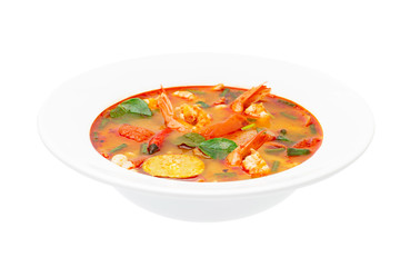 Closeup plate of traditional thai soup - tom yum kung isolated at white background.