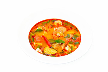 Closeup plate of traditional thai soup - tom yum kung isolated at white background.