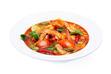Closeup plate of traditional thai soup - tom yum kung with shrimps and tomatoes isolated at white background.