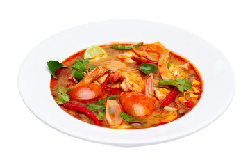 Closeup plate of traditional thai soup - tom yum kung with shrimps and tomatoes isolated at white...