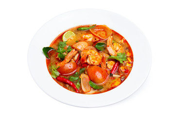 Closeup plate of traditional thai soup - tom yum kung with shrimps and tomatoes isolated at white background.