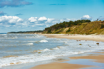 Rocky coast line of the Baltic sea in Latvia, during sunny summer day with blue sky.