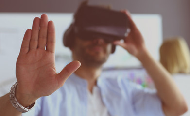 Young male software programmer testing a new app with 3d virtual reality glasses in office.