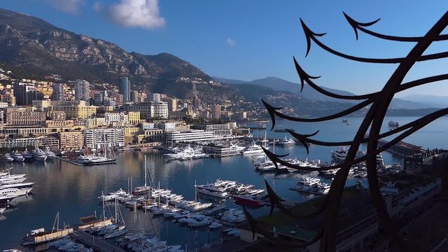 Monaco city harbor with sail boats, downtown buildings and mountain skyline. Royalty free Full HD stock footage related to Mediterranean European life, travel, culture, politics, economics, history. 