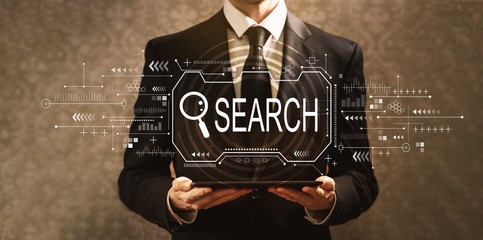 Searching theme with businessman holding a tablet computer