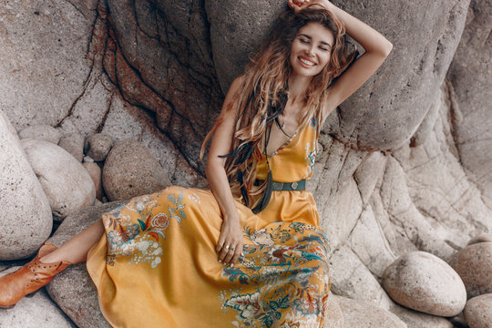 cheerful beautiful young boho style model on the stone beach