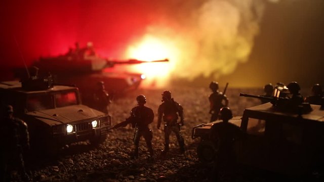 War Concept. Military silhouettes fighting scene on war foggy sky background at night. Armored vehicles with soldiers ready to attack. Artwork decoration. Selective focus