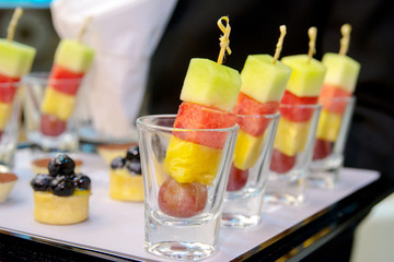 Mixed exotic fruits on skewers, party snack on slate platter
