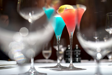 Red cocktail in selective focus over the other glasses for abstract mood